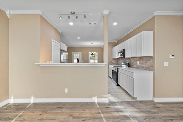 kitchen with white cabinetry, crown molding, stainless steel appliances, and an inviting chandelier