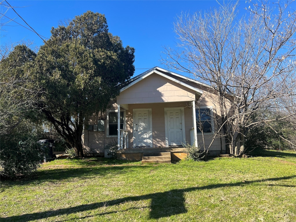 bungalow-style home with a front lawn