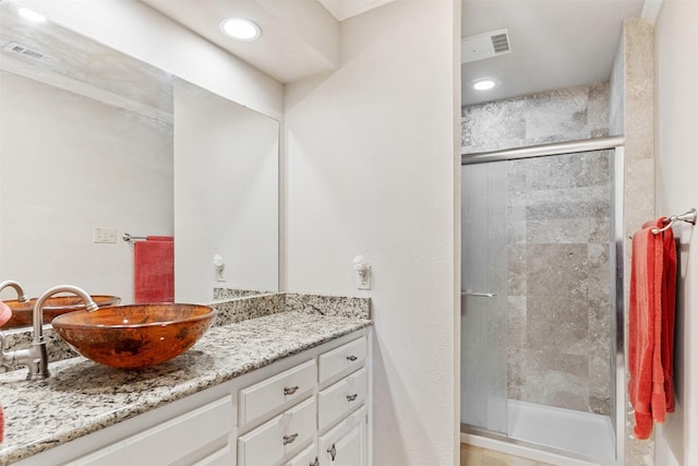 bathroom with vanity and a shower with shower door