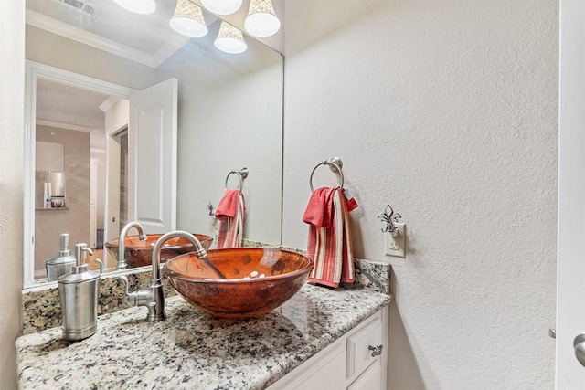 bathroom featuring crown molding and vanity