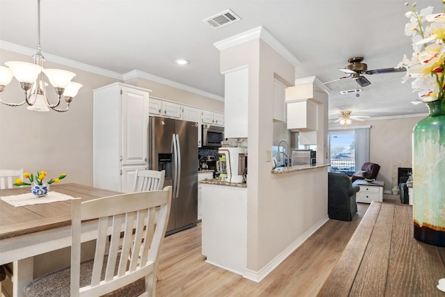 kitchen featuring crown molding, decorative light fixtures, light wood-type flooring, stainless steel appliances, and white cabinets