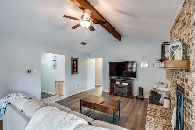 living room with hardwood / wood-style flooring, ceiling fan, a fireplace, and lofted ceiling with beams