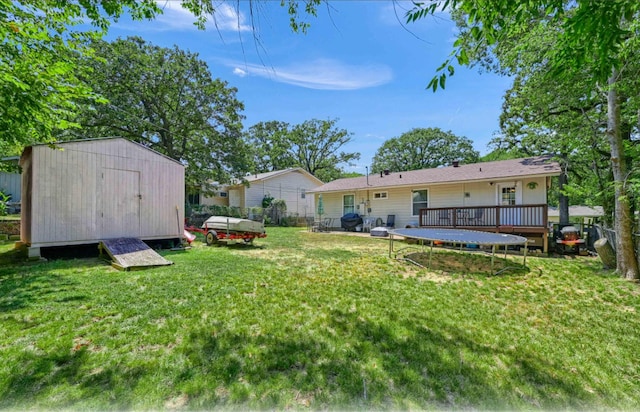 view of yard featuring a trampoline, a shed, and a deck