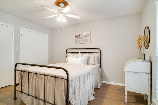 bedroom with hardwood / wood-style flooring, ceiling fan, and a textured ceiling