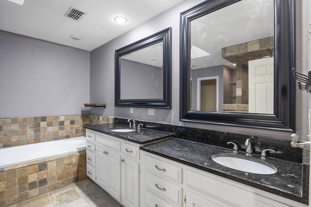 bathroom with vanity and a relaxing tiled tub