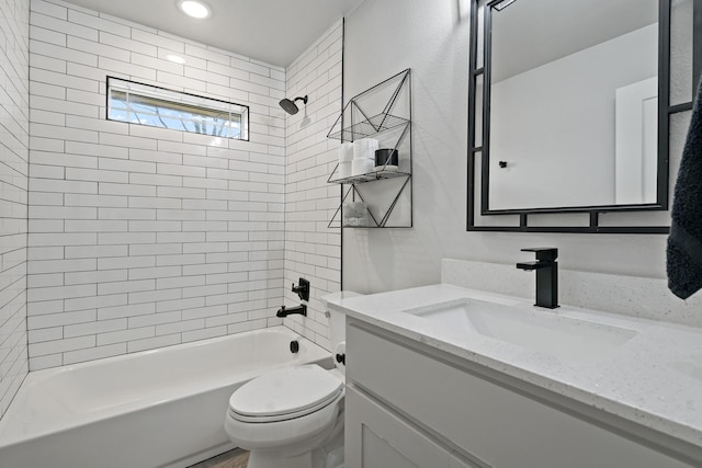 full bathroom with tiled shower / bath, vanity, and toilet