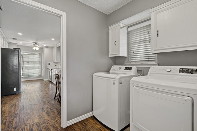 washroom with washer and dryer, dark hardwood / wood-style floors, cabinets, ceiling fan, and a textured ceiling