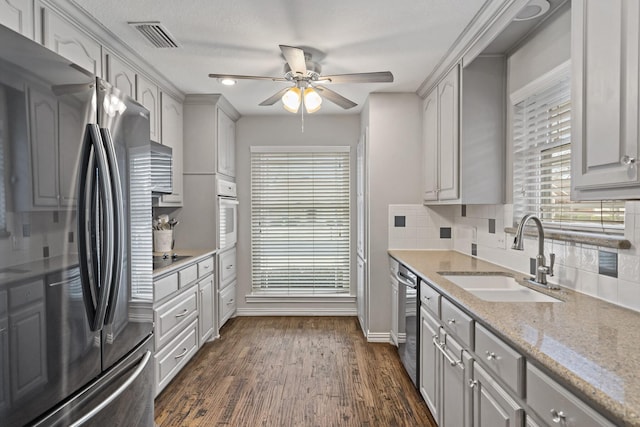 kitchen with sink, dark wood-type flooring, gray cabinetry, stainless steel appliances, and tasteful backsplash