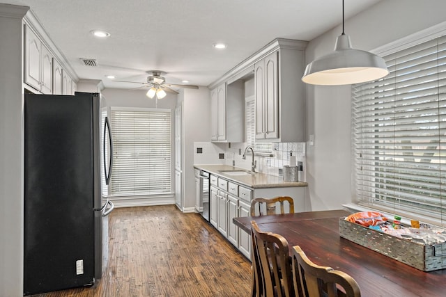 kitchen with appliances with stainless steel finishes, decorative light fixtures, sink, white cabinets, and decorative backsplash