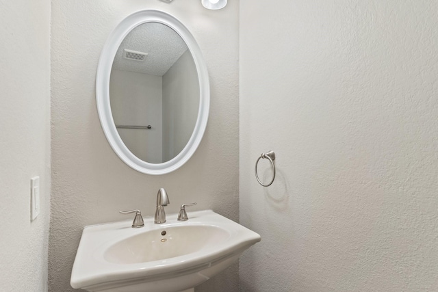 bathroom featuring sink and a textured ceiling