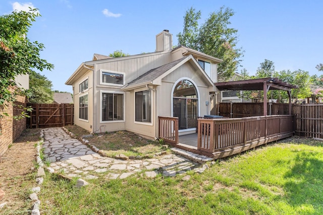 back of property with a wooden deck, a yard, and a pergola