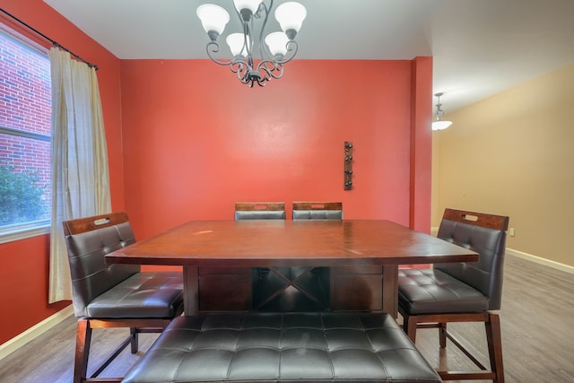 dining space featuring wood-type flooring and a chandelier