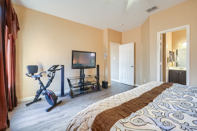 bedroom with ceiling fan, connected bathroom, and hardwood / wood-style floors