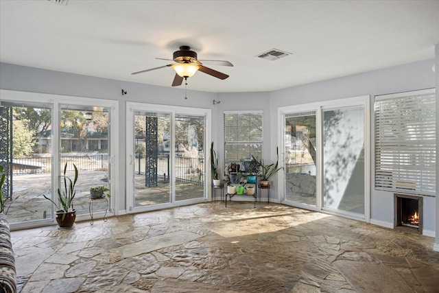 unfurnished sunroom featuring ceiling fan