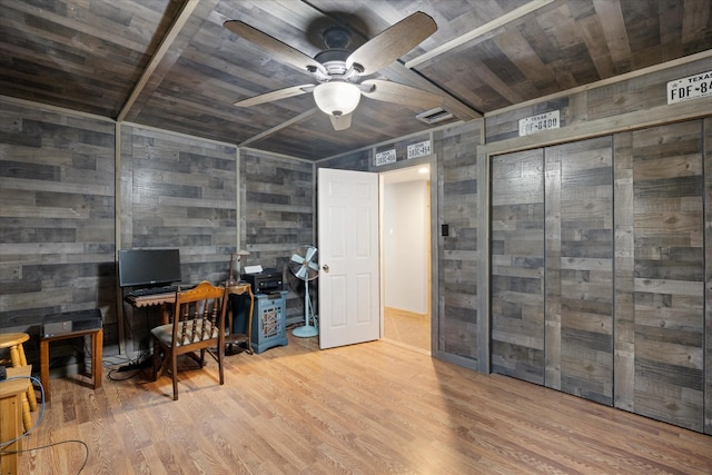 home office featuring wood ceiling, wooden walls, ceiling fan, and light wood-type flooring