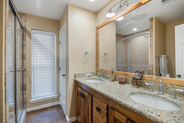 bathroom featuring an enclosed shower, wood-type flooring, and vanity