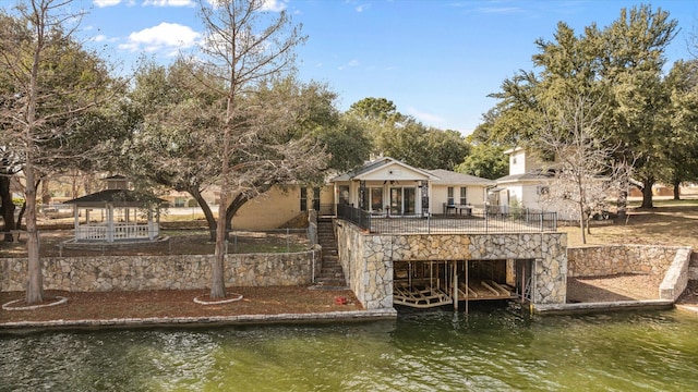 dock area featuring a gazebo and a deck with water view