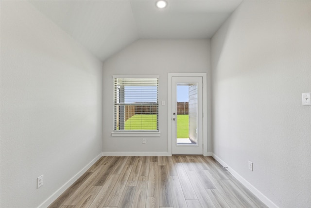 empty room featuring vaulted ceiling and light hardwood / wood-style flooring