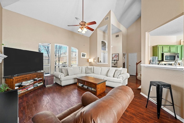 living room featuring ceiling fan, dark hardwood / wood-style floors, and high vaulted ceiling