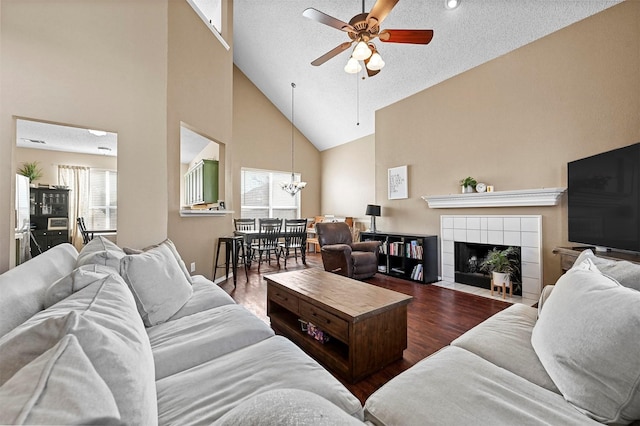 living room featuring hardwood / wood-style flooring, a tiled fireplace, and a textured ceiling