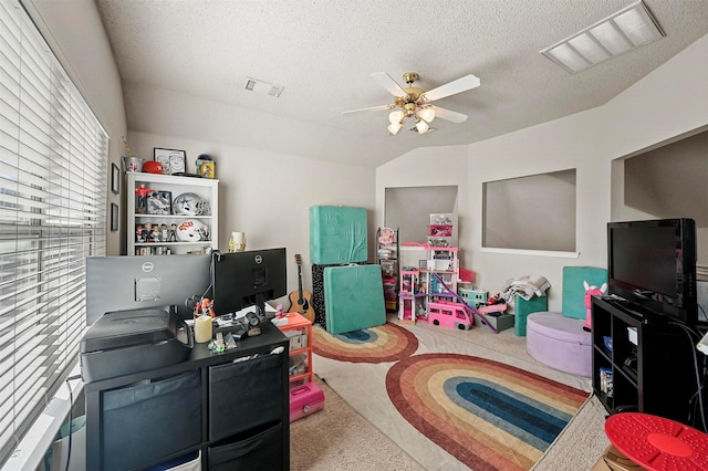 recreation room with ceiling fan, carpet flooring, and a textured ceiling