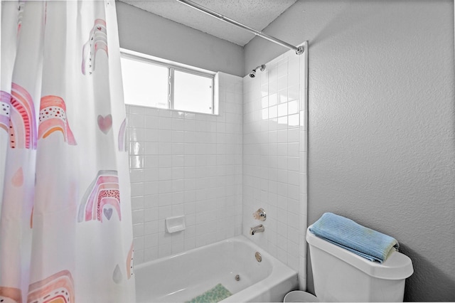 bathroom featuring toilet, tiled shower / bath combo, and a textured ceiling