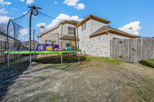 rear view of property with a trampoline