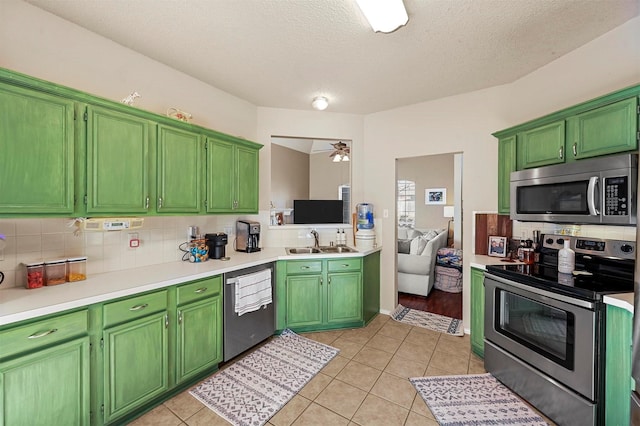 kitchen featuring sink, light tile patterned floors, stainless steel appliances, and a textured ceiling