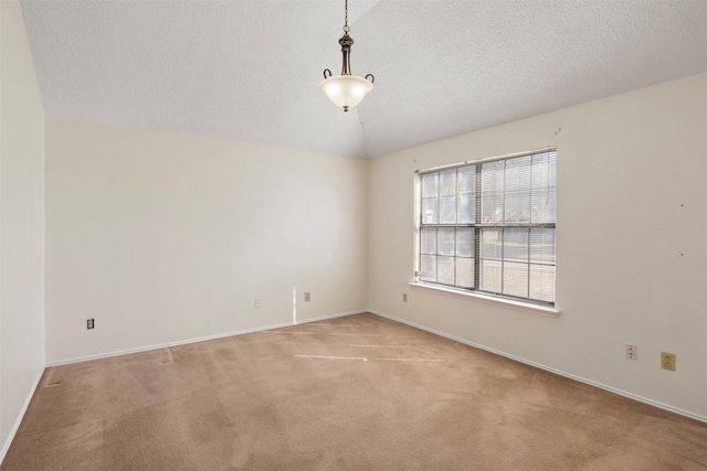 carpeted empty room featuring lofted ceiling and a textured ceiling