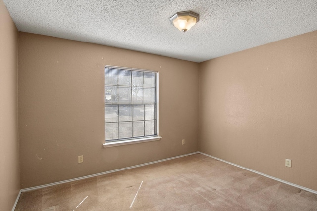 carpeted empty room featuring a textured ceiling