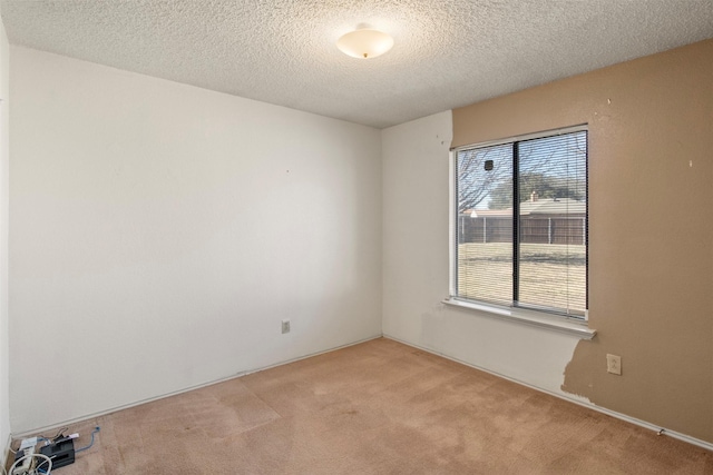 carpeted spare room with a textured ceiling