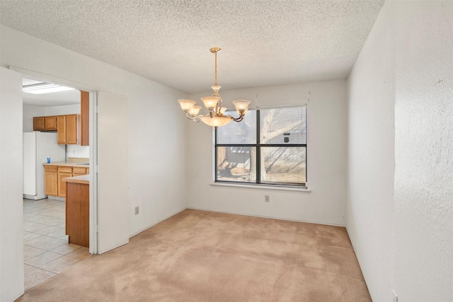 unfurnished dining area with light colored carpet, a textured ceiling, and a notable chandelier