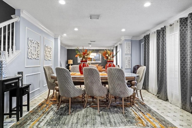 dining area featuring ornamental molding and a textured ceiling