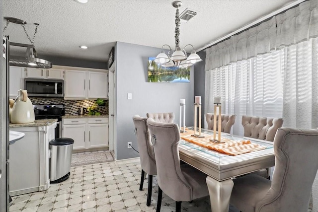 dining area featuring a notable chandelier and a textured ceiling