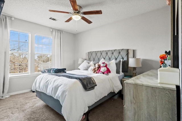 bedroom with ceiling fan, carpet flooring, and a textured ceiling