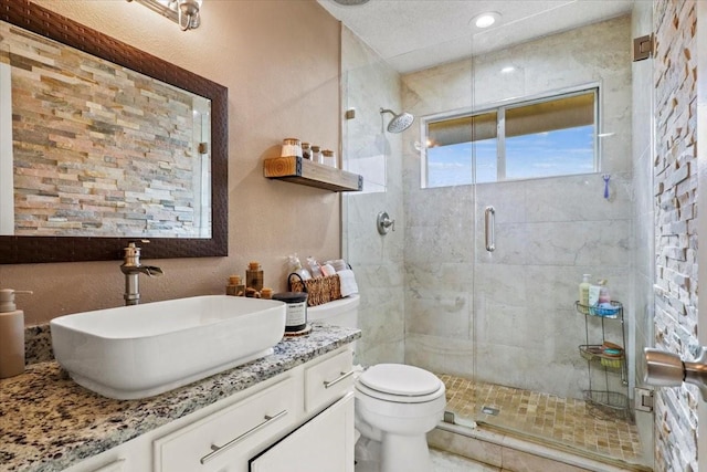 bathroom featuring vanity, toilet, and an enclosed shower