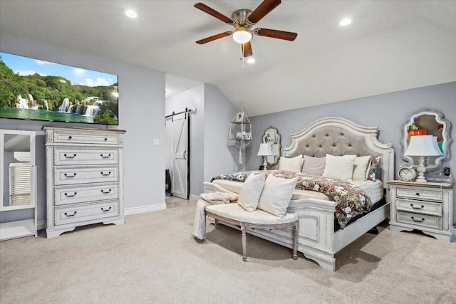 bedroom featuring vaulted ceiling, light colored carpet, a barn door, and ceiling fan