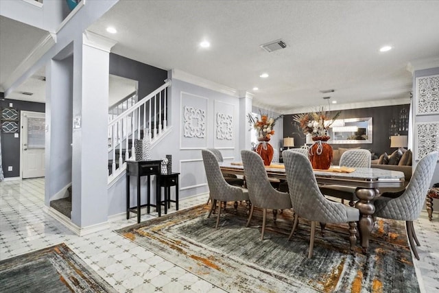 dining area with crown molding, decorative columns, and a textured ceiling