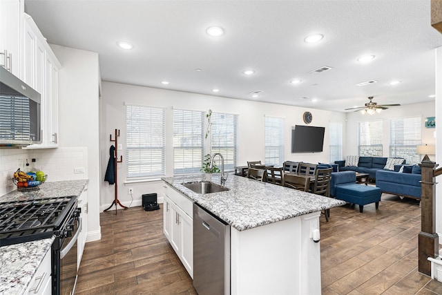 kitchen featuring stainless steel appliances, sink, a center island with sink, and white cabinets