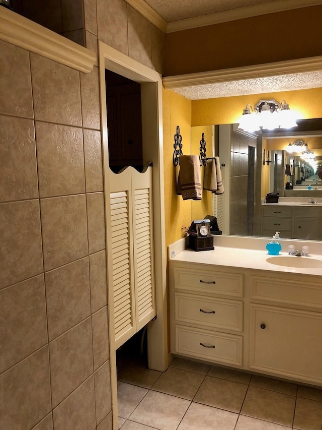 bathroom featuring tile patterned flooring, crown molding, and vanity