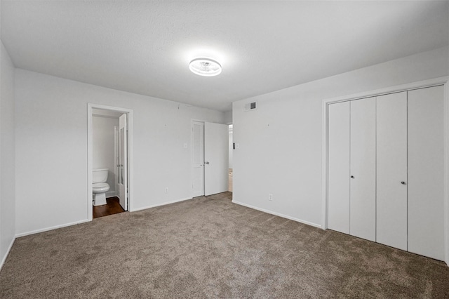 unfurnished bedroom with carpet floors and connected bathroom