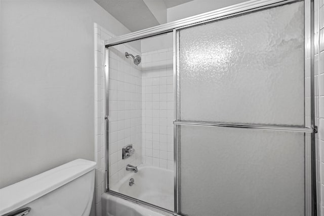 bathroom featuring enclosed tub / shower combo and toilet