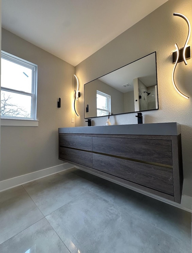 bathroom featuring vanity, concrete floors, and walk in shower