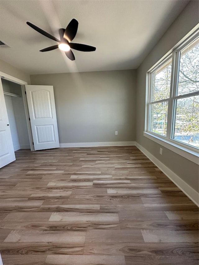 unfurnished bedroom with light hardwood / wood-style flooring, a closet, and ceiling fan