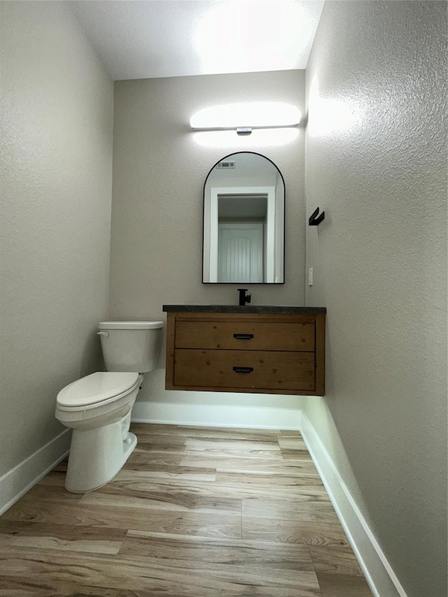 bathroom featuring vanity, hardwood / wood-style floors, and toilet