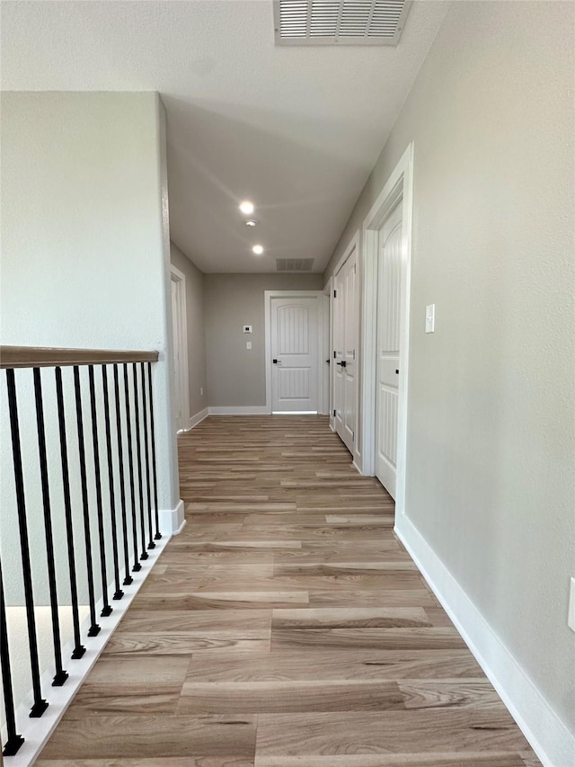 hallway with light hardwood / wood-style floors