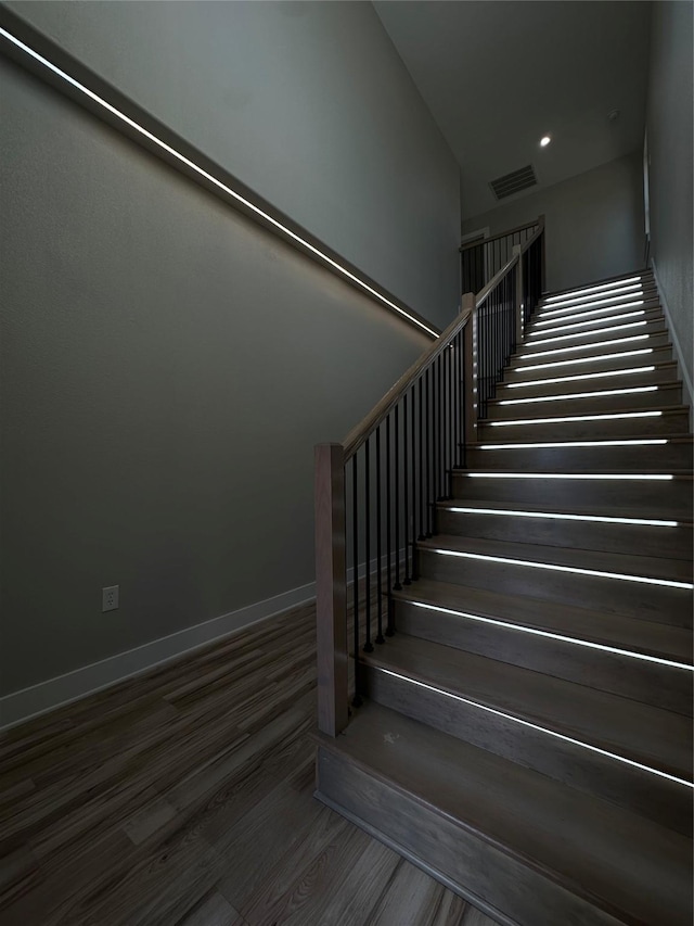 staircase with hardwood / wood-style floors