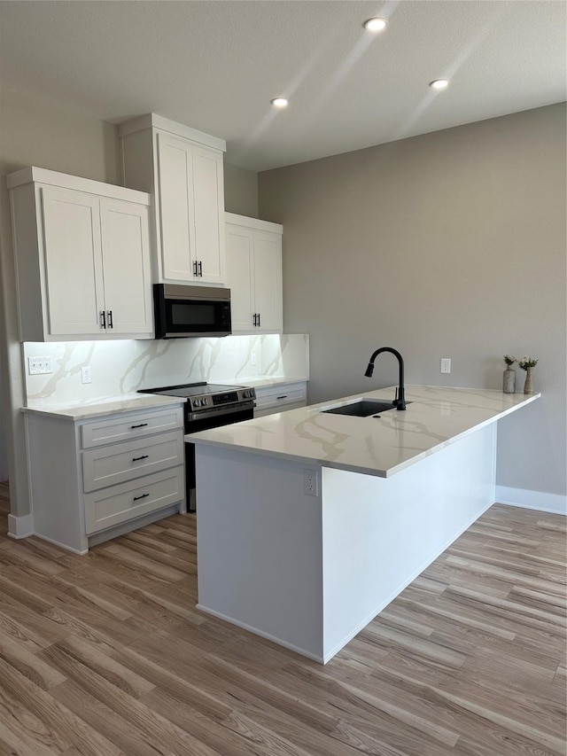 kitchen with tasteful backsplash, sink, range with electric stovetop, and white cabinets