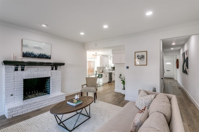 living room featuring ornamental molding, hardwood / wood-style floors, and a brick fireplace