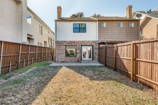 rear view of property with french doors, a yard, and a patio area